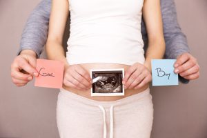 Pregnant woman with two post-its, boy and girl