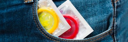 Two condoms on a white background with the words STD prevention written in bold text.